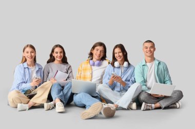 Işık arka planında oturan bir grup öğrenci