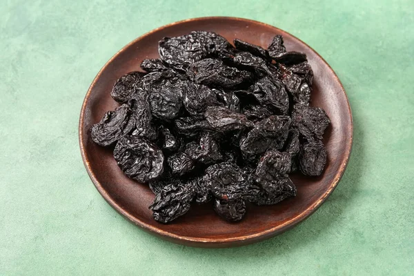 Yeşil arka planda lezzetli kurutulmuş erikli tabak.