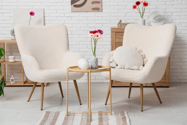 Koltuklar ve güzel Gerbera çiçekleri oturma odasının içinde.