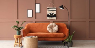 Koltuğu, hasır masası ve bitkileri olan şık bir oturma odası.