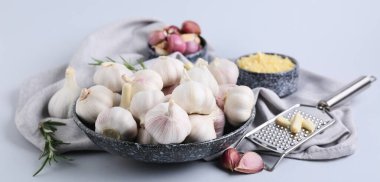 Taze sarımsaklı kase ve gri arka planda biberiye.