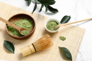 Beyaz arka planda Chasen ve Chashaku ile bir kase kibrit tozu.