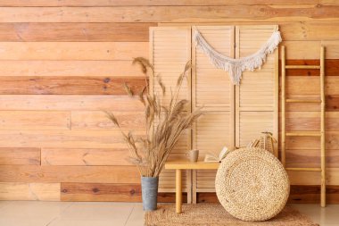 Bankta, puf ve katlanmış ekranlı kitapların olduğu odanın içi