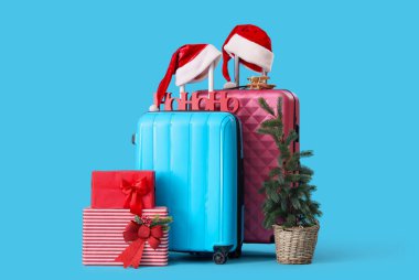 Mavi arka planda Noel ve seyahat aksesuarları olan bavullar