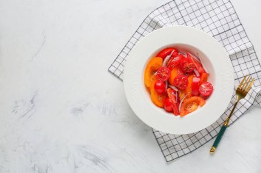 Beyaz arka planda kırmızı soğanlı taze domates salatası.