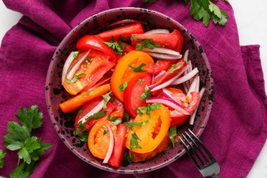 Kırmızı soğanlı taze domates salatası ve beyaz arka planda maydanoz.