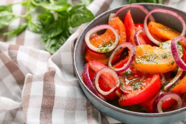 Bir kase taze domates salatası, peçetede kırmızı soğan, yakın plan.
