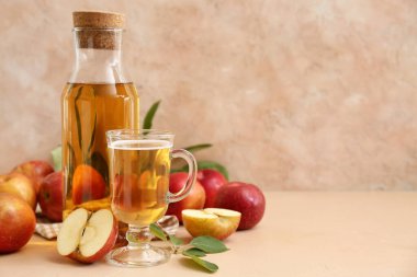 Bej arka planda meyveli taze elma şarabı şişesi ve cam bardak.