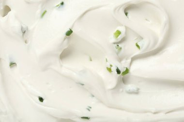 Arka planda doğranmış yeşil soğanlı lezzetli ekşi kremanın yakın görüntüsü