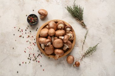 Taze mantarlı ahşap tabak, kekik ve beyaz arka planda biber.