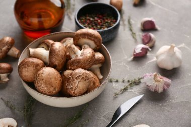 Taze mantarlı kase, biberli ve gri arka planda kekik, yakın plan.