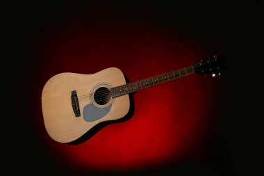 Kırmızı arkaplanda modern akustik gitar