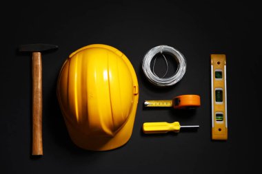 Siyah arkaplan, üst görünüm üzerine sert şapka ve inşaat araçları