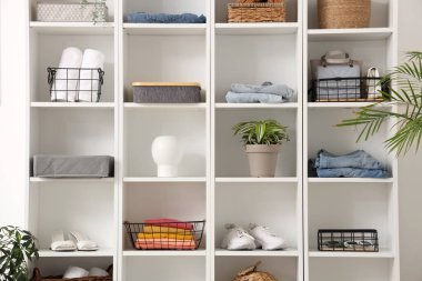 Giysileri, aksesuarları ve dekorları olan büyük bir raf ünitesi.