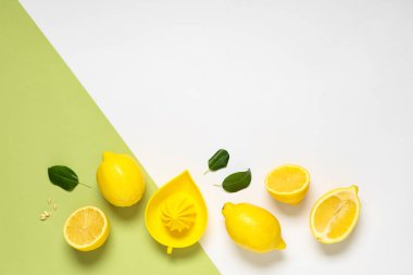 Renk arkaplanında taze limon ve el sıkacağı olan kompozisyon