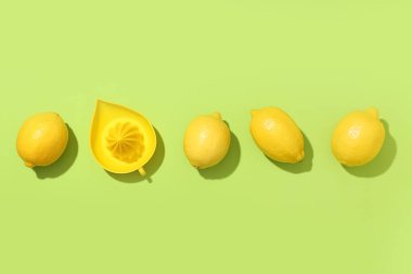 Yeşil arka planda taze limonlu kompozisyon ve el sıkacağı.