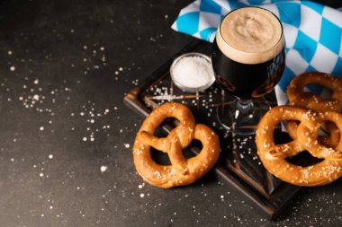 Bir bardak soğuk bira ve siyah grunge arka planda lezzetli krakerler, yakın plan.