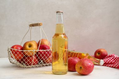 Taze elma şarabı şişeleri ve beyaz arka planda meyveler