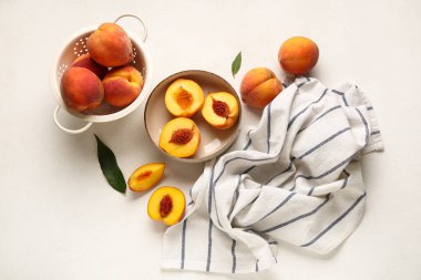 Beyaz arka planda olgun şeftalili kevgir ve kevgir.