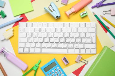 Beyaz arkaplanda farklı okul gereçleri ve bilgisayar klavyesi seti, yakın plan