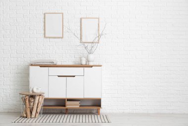 Beyaz tuvaletli, tablolu ve boş çerçeveli odanın içi