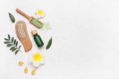 Beyaz grunge arka planda saç fırçası, vitamin kapsülleri ve bir şişe kozmetik ürünler içeren kompozisyon