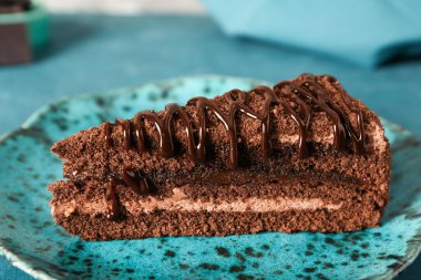 Üzerinde mavi grunge arka planı olan lezzetli çikolatalı pasta tabağı, yakın plan.