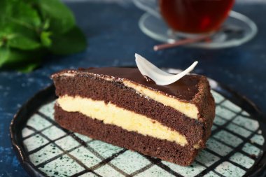 Üzerinde mavi grunge arka planda lezzetli çikolatalı pasta olan bir tabak.