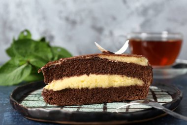 Gri duvarın yakınındaki mavi masada lezzetli çikolatalı kek tabağı.