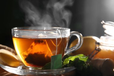 Bir fincan sıcak siyah çay, üzerinde nane yaprakları olan, yakın plan.