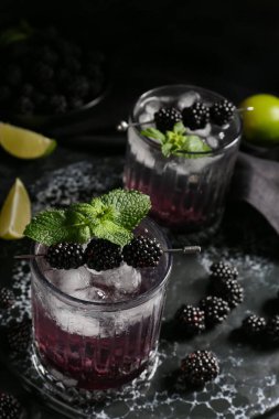 Siyah arka planda lezzetli böğürtlenli limonata, yakın plan.