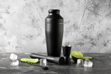 Gri grunge arka planda modern barmen seti ve kokteyl malzemeleri