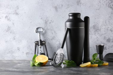 Gri grunge arka planda modern barmen seti ve kokteyl malzemeleri, yakın plan.