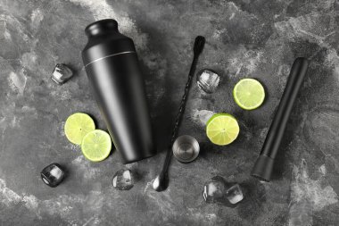 Gri grunge arka planda modern barmen seti ve kokteyl malzemeleri