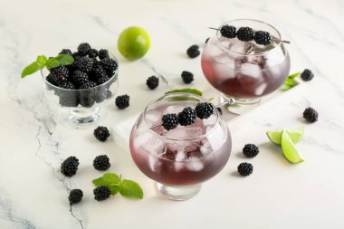 Lezzetli böğürtlenli limonata ve mermer arka planda malzemeler, yakın plan.