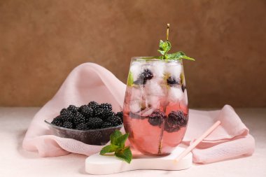 Lezzetli böğürtlenli limonata ve bej grunge arka planda sıva podyumu, yakın plan.