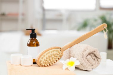 Masaj fırçası, havlu, şişe ve kozmetik ürünleri banyonun içinde, yakın plan.