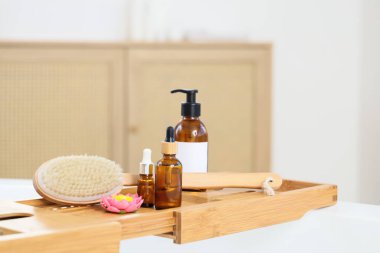 Küvet tepsisi masaj masalı vücut fırçası ve banyo içinde kozmetik ürünler, yakın plan.