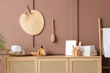 Temiz havlular, ayna, masaj vücut fırçaları ve banyonun içindeki kozmetik ürünlerin olduğu çekmeceler, yakın plan.