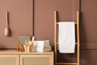 Temiz havluları olan çekmeceler, banyo içinde ayna ve masaj vücut fırçaları, yakın plan.