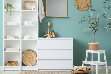 Odanın içinde farklı banyo malzemeleri olan çekmeceler ve raflar.