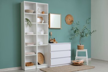 Odanın içinde farklı banyo malzemeleri olan çekmeceler ve raflar.