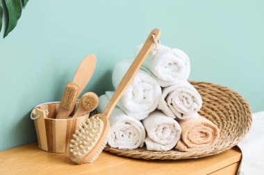 Tahta tutucu, masaj vücut fırçası ve çekmecelerin üstündeki temiz havlular, yakın plan.