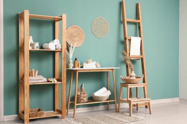 Odanın içinde farklı banyo malzemeleri olan raf ve masa.