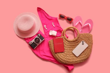Pasaport, mayo, fotoğraf makinesi ve pembe arka planda plaj aksesuarları, yakın plan.
