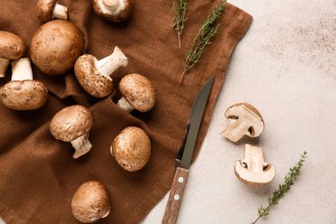 Peçete, bıçak ve çiğ mantarlar beyaz grunge arka planda, yakın plan