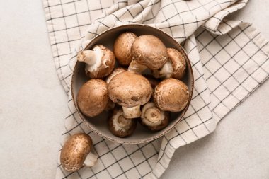 Beyaz grunge arka planda çiğ şampiyon mantarlı kase, yakın plan