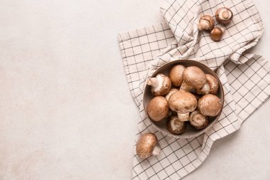 Beyaz grunge arka planda çiğ şampiyon mantarlı kase, yakın plan