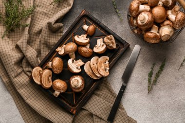 Kesme tahtası ve süzgeç ham şampiyon mantarlı Grunge arka planda, yakın plan