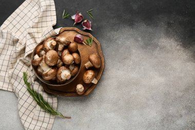 Tepsi, kase ve arkaplanda çiğ şampiyon mantarları olan kompozisyon